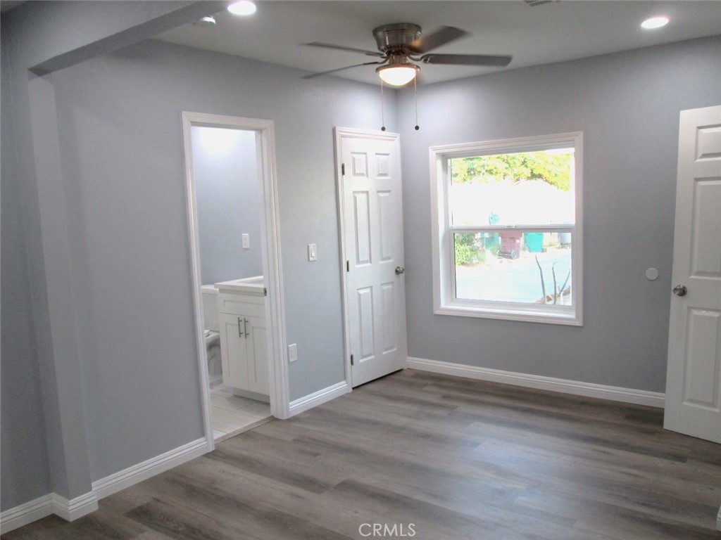 44552 Arabia Street Indio, CA 92201 - Photo 10 of 49 an empty room with wooden floor ceiling fan and windows