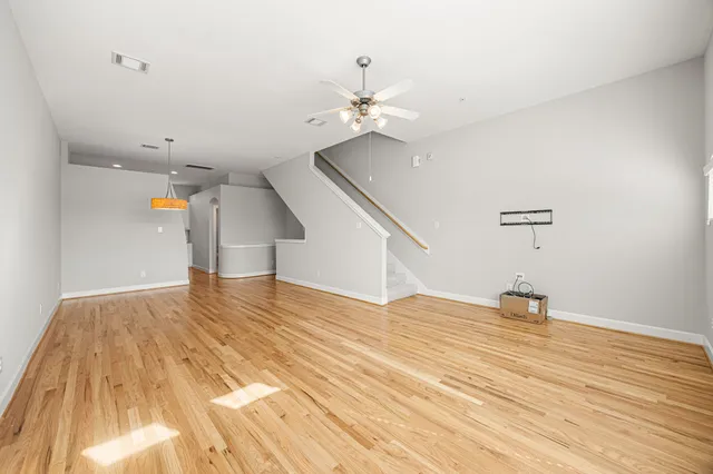 a view of a room with wooden floor and ceiling fan