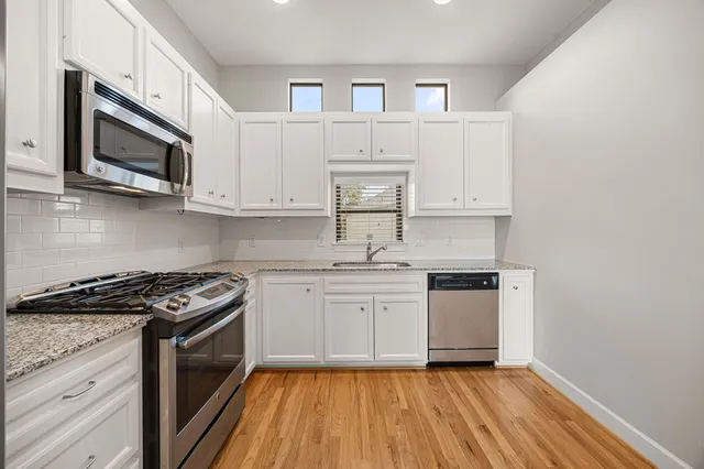 a kitchen with stainless steel appliances granite countertop a stove a microwave and a sink