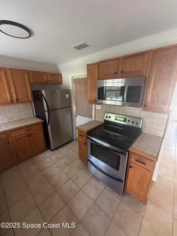 a kitchen with stainless steel appliances a stove a microwave and a refrigerator