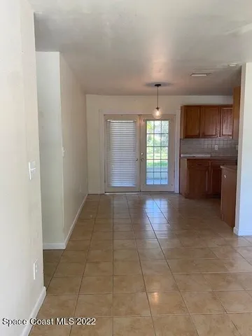 a view of an empty room with a kitchen