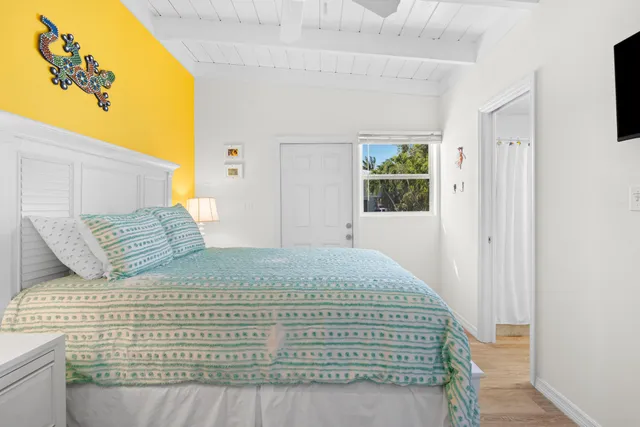 a large bed sitting in a bedroom next to a window