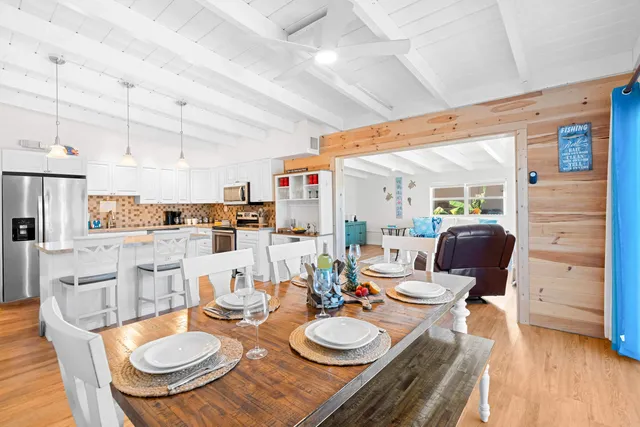 a dining room with furniture a kitchen and chandelier