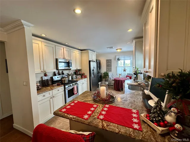 a living room with furniture a rug kitchen view and a window