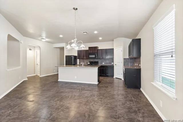 a view of a kitchen with refrigerator and a stove top oven