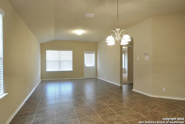a view of a room with a chandelier fan and windows