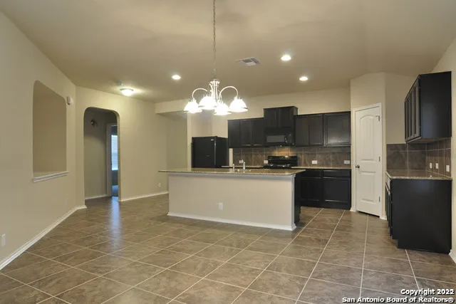 a kitchen with a sink a counter top space cabinets and stainless steel appliances