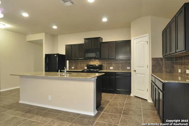 a kitchen with stainless steel appliances granite countertop a stove a sink and a refrigerator