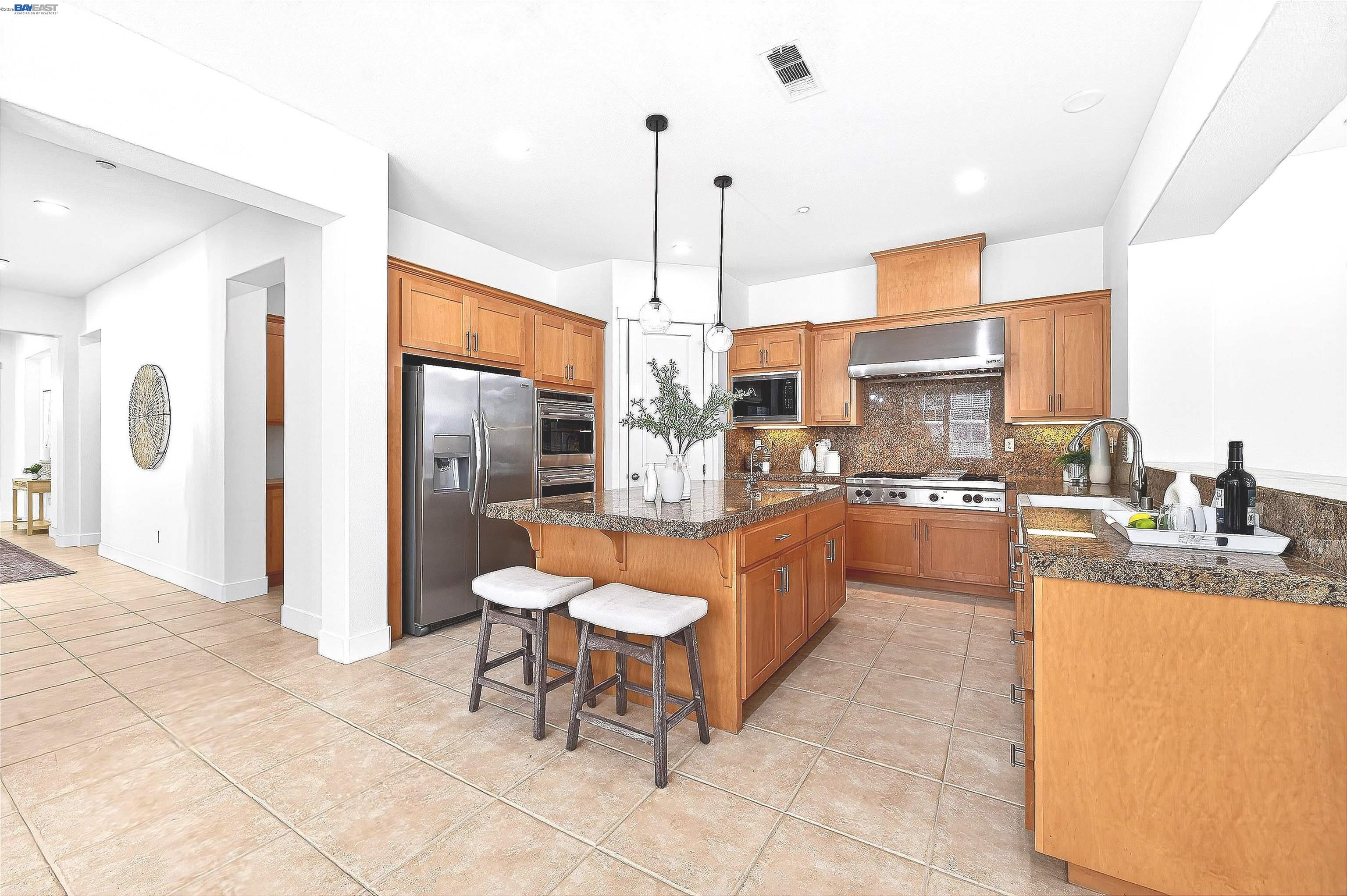 5564 Stockton Loop Livermore, CA 94550 - Photo 8 of 45 a large kitchen with kitchen island granite countertop a large counter top and stainless steel appliances