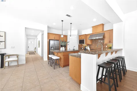 a large kitchen with kitchen island a sink table and chairs