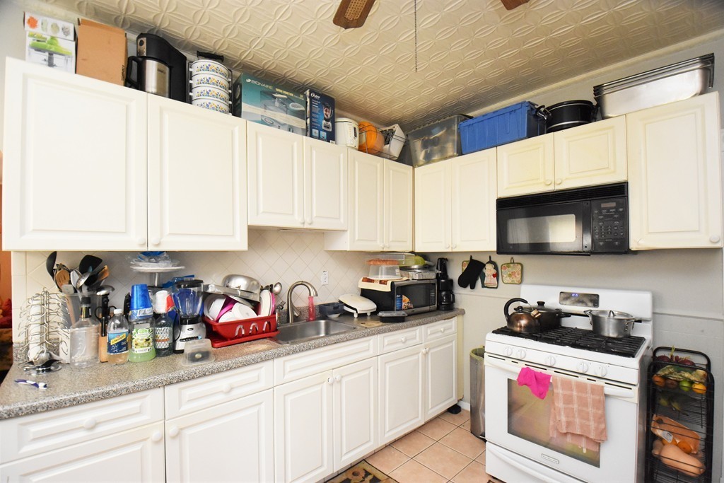 84 Vernal Street Everett, MA 02149 - Photo 11 of 26 a kitchen with stainless steel appliances granite countertop a sink a stove and cabinets