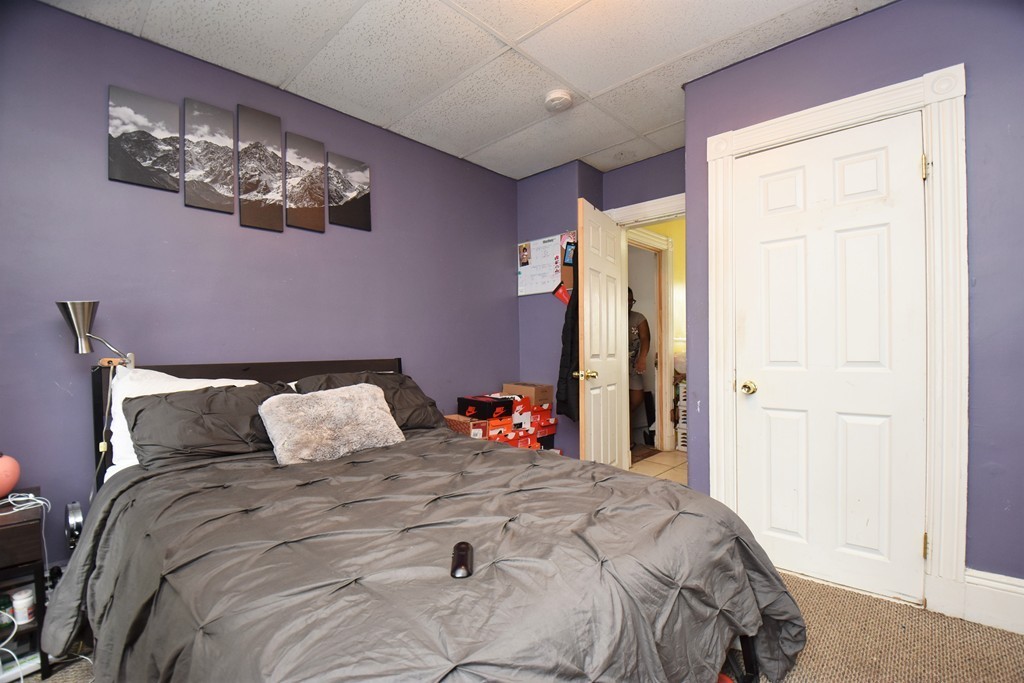 84 Vernal Street Everett, MA 02149 - Photo 14 of 26 a bedroom with a bed and a chandelier