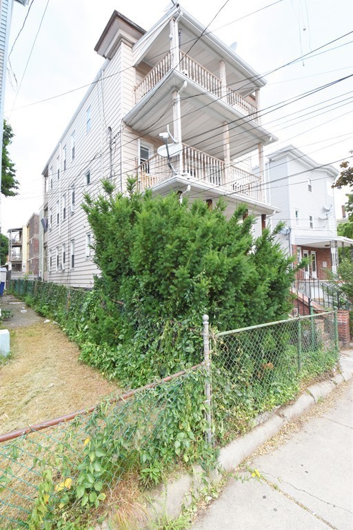 84 Vernal Street Everett, MA 02149 - Photo 3 of 26 a view of a building with a garden
