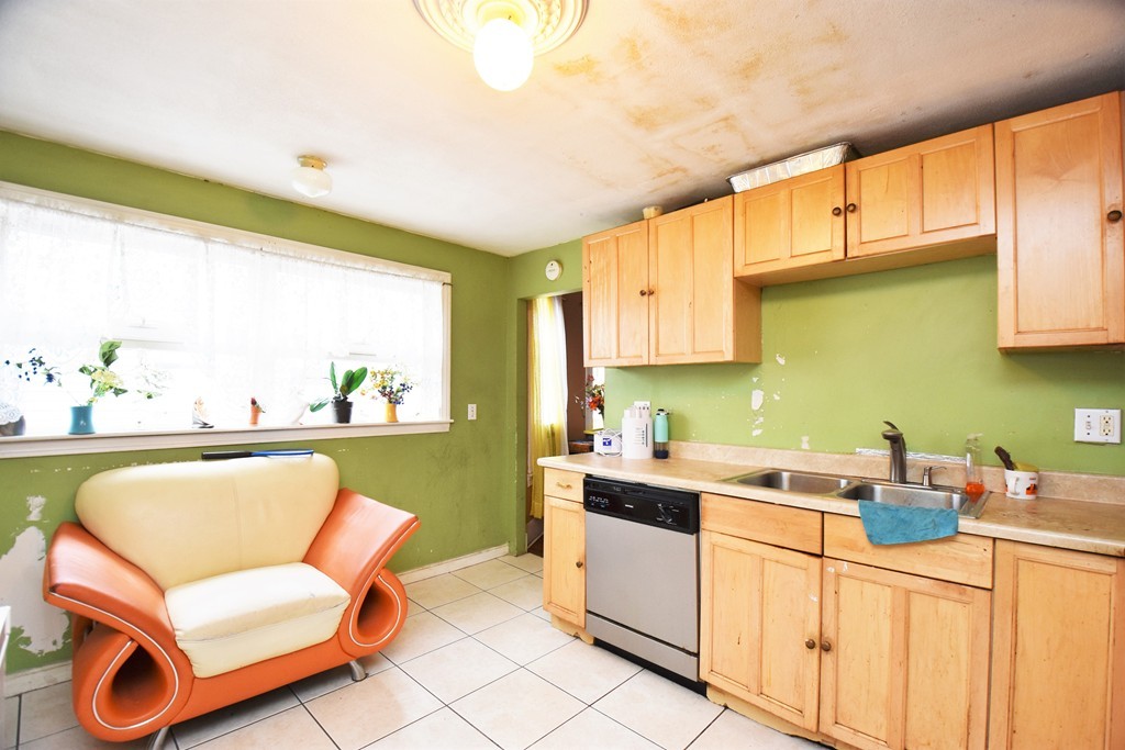 84 Vernal Street Everett, MA 02149 - Photo 5 of 26 a kitchen with a sink chairs and cabinets