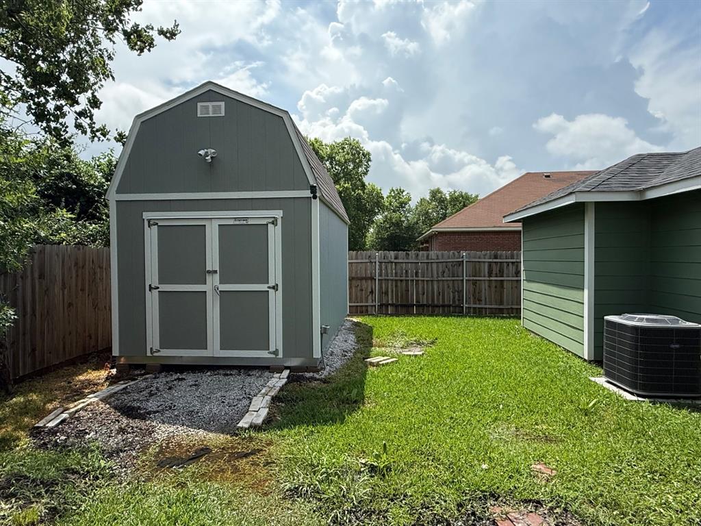 505 Thomas Street Terrell, TX 75160 - Photo 13 of 38 Detached storage shed with barn-style roof, double doors, and a gravel base