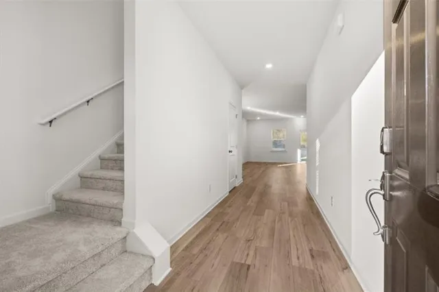a view of a hallway with wooden floor and staircase
