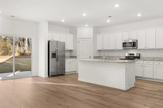 a kitchen with stainless steel appliances granite countertop a refrigerator and a stove top oven