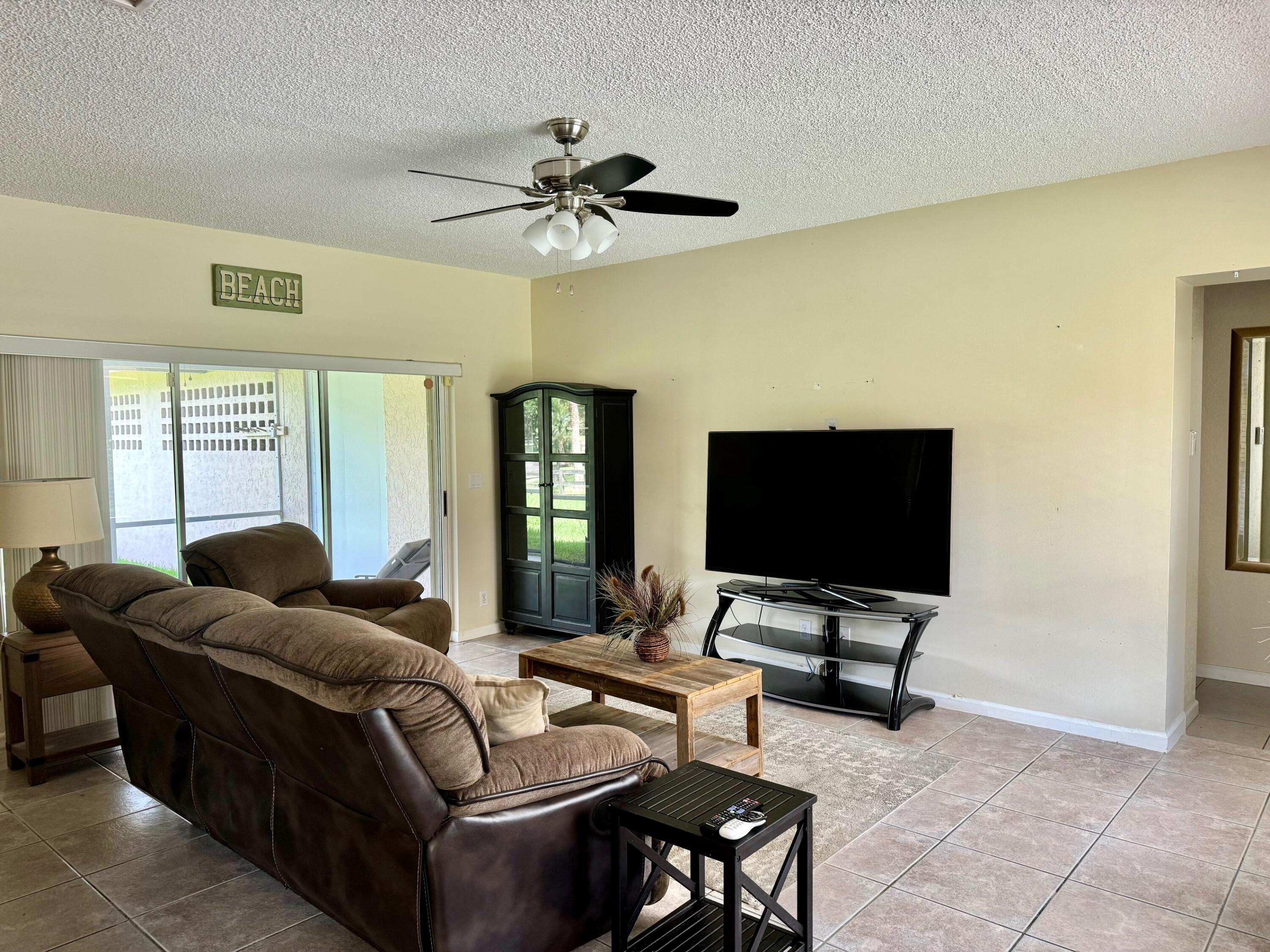 11333 Acme Road Wellington, FL 33414 - Photo 54 of 83 a living room with furniture and a flat screen tv