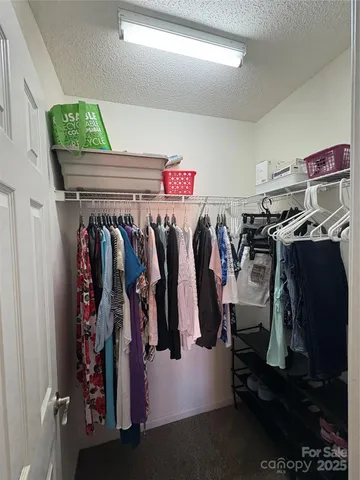 a view of walk in closet with clothes
