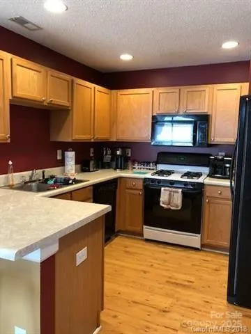 a kitchen with stainless steel appliances granite countertop a stove a sink and a microwave