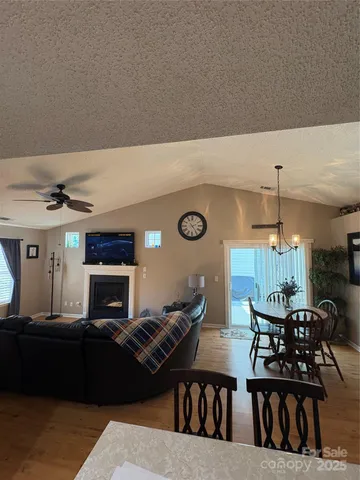 a living room with furniture a fireplace and a chandelier
