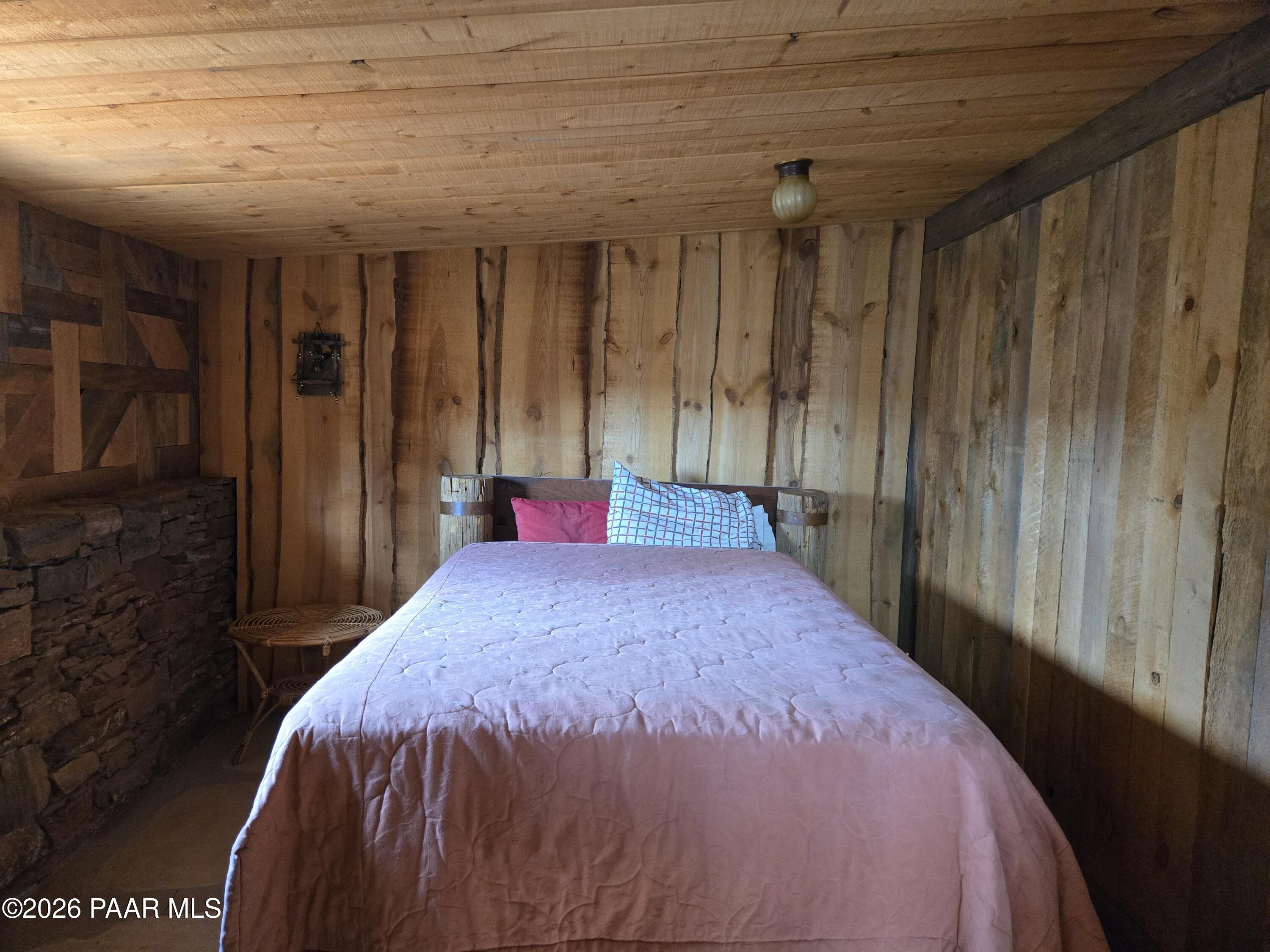 38125 North Snake Road Ash Fork, AZ 86320 - Photo 19 of 34 a bed sitting in a bedroom next to a window and a wooden door