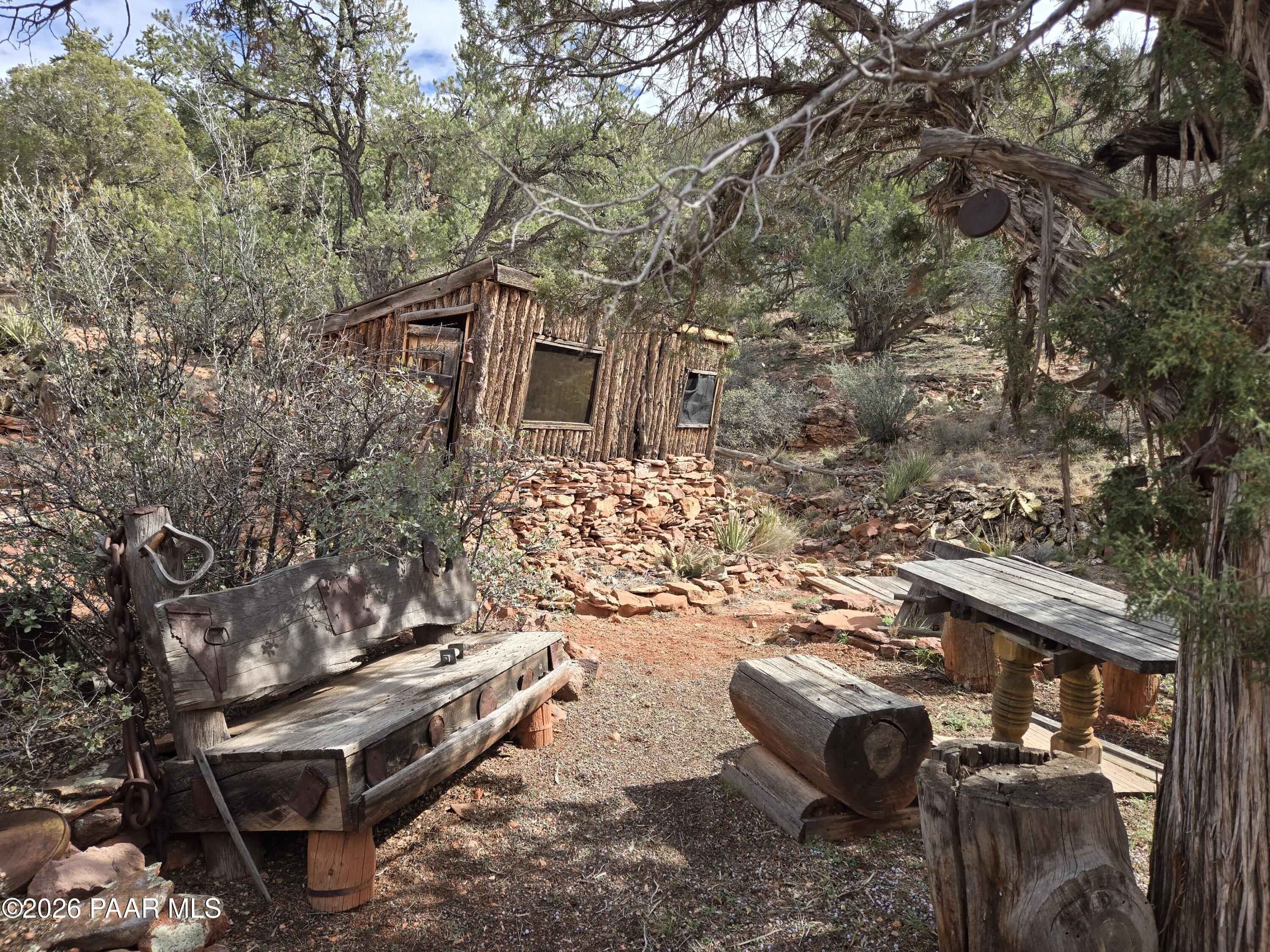 38125 North Snake Road Ash Fork, AZ 86320 - Photo 27 of 34 a backyard of a house with large trees and lawn chairs