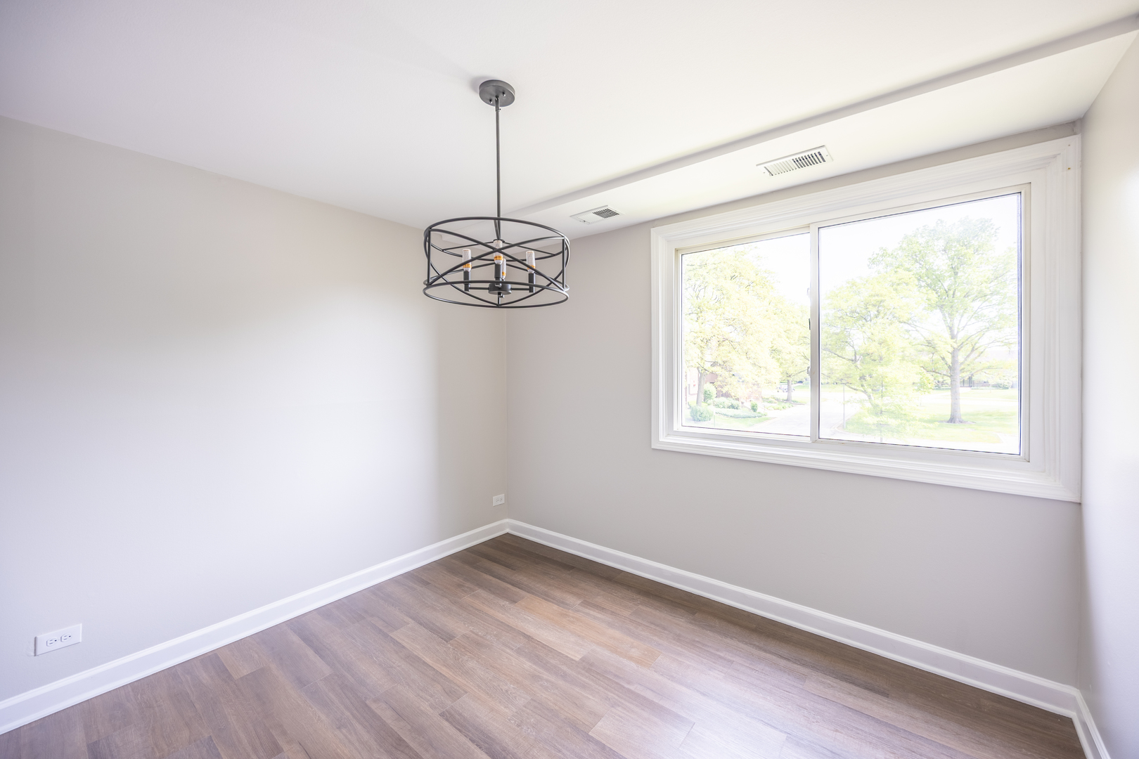 450 Raintree Court, Unit 2B Glen Ellyn, IL 60137 - Photo 6 of 28 a view of empty room with window and chandelier