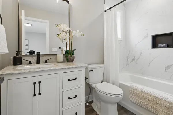 a bathroom with a granite countertop toilet sink and mirror