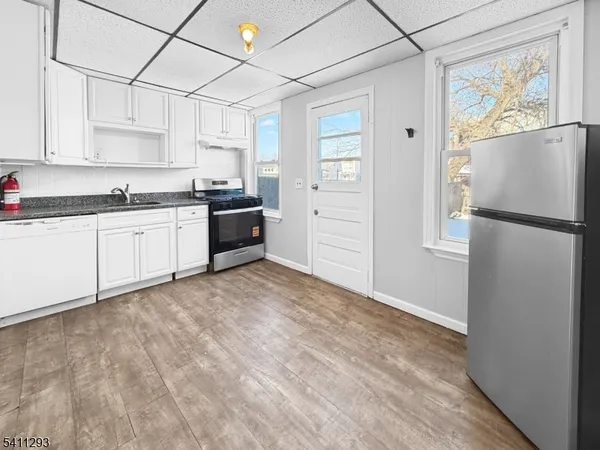 a kitchen with granite countertop a refrigerator and a sink