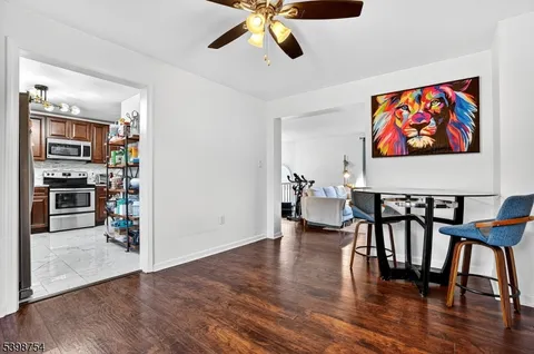 a view of a livingroom with furniture hardwood floor and a ceiling fan