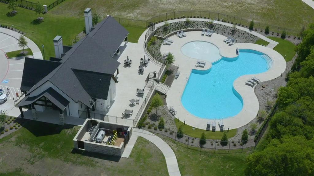 2721 Old Shire Path Road Prosper, TX 75078 - Photo 36 of 39 Expansive community outdoor pool area featuring a freeform swimming pool, integrated shallow lounging area, and surrounding concrete patio