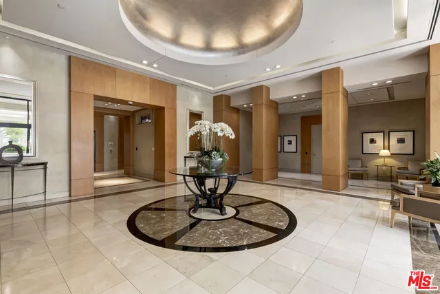 a living room with stainless steel appliances kitchen island granite countertop a refrigerator and a sink