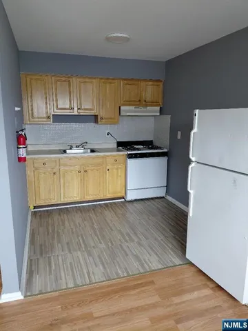 a kitchen with wooden floors and appliances
