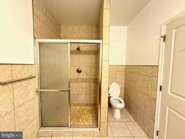 a bathroom with a granite countertop shower a toilet and a sink