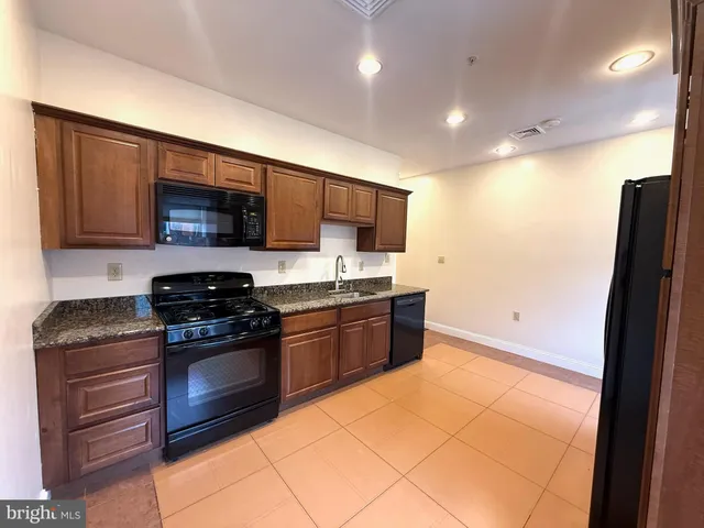 a kitchen with stainless steel appliances granite countertop a stove a sink and a refrigerator