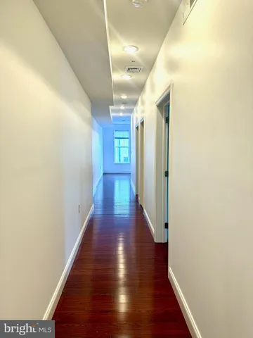 a view of a hallway with wooden floor