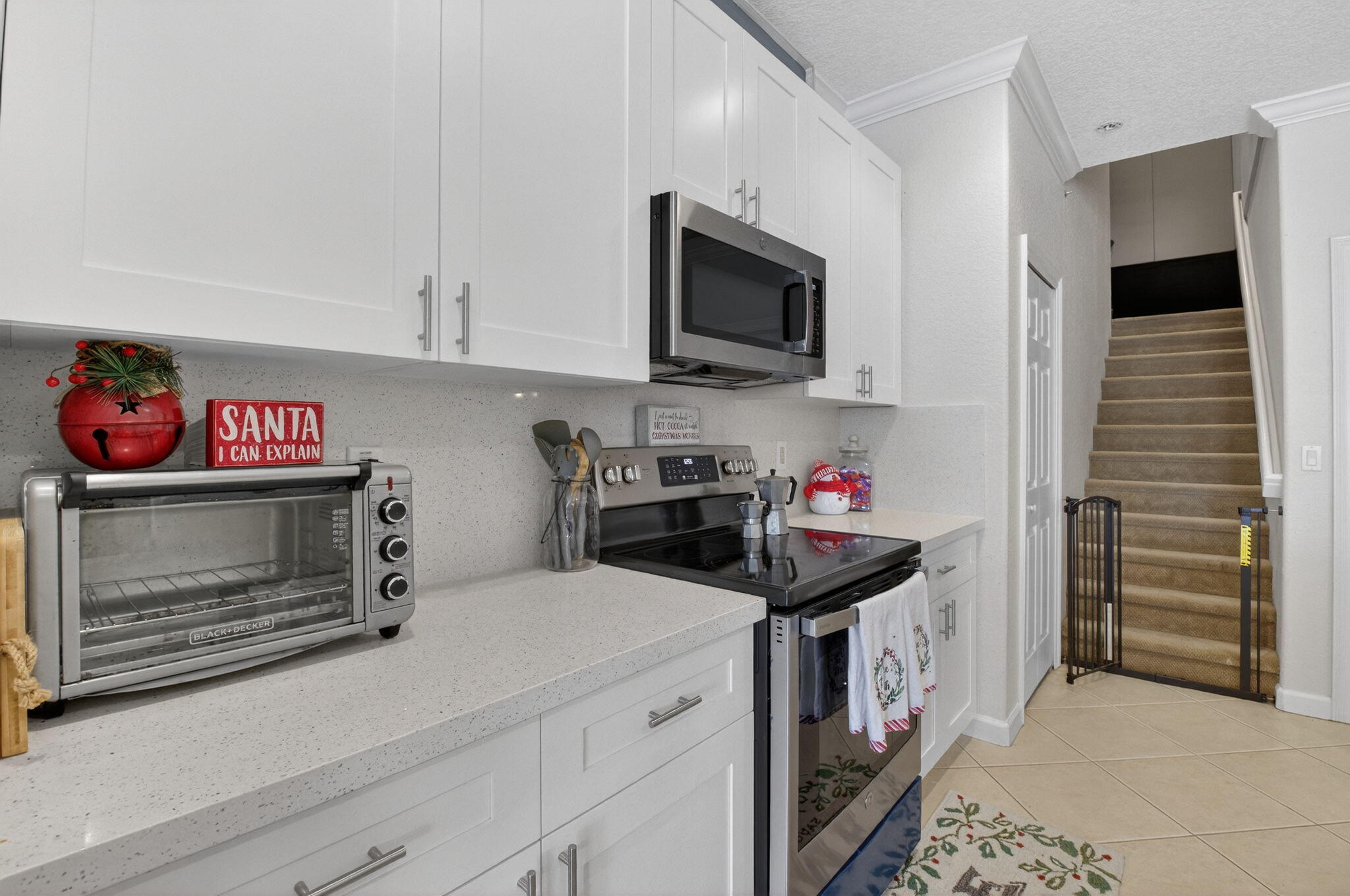 7209 Serrano Terrace Delray Beach, FL 33446 - Photo 16 of 48 a kitchen with a microwave stove top oven and cabinets