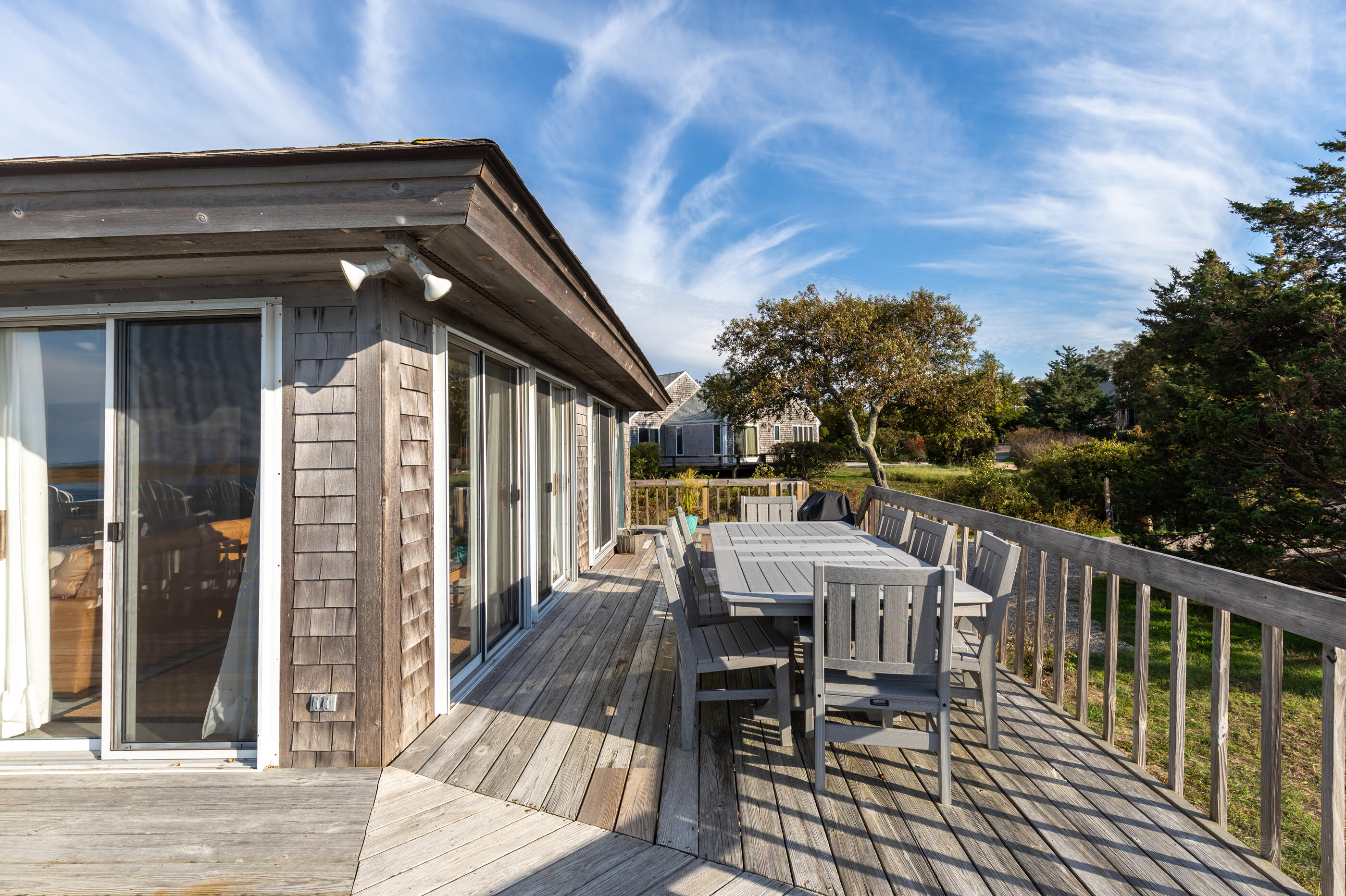 20 Beach Road Eastham, MA 02642 - Photo 8 of 23 a view of a patio with table and chairs and floor to ceiling window