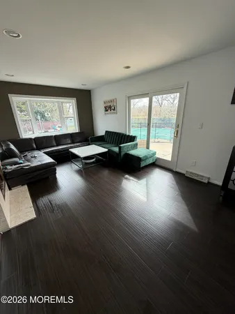 a view of a livingroom with furniture hardwood floor and a window