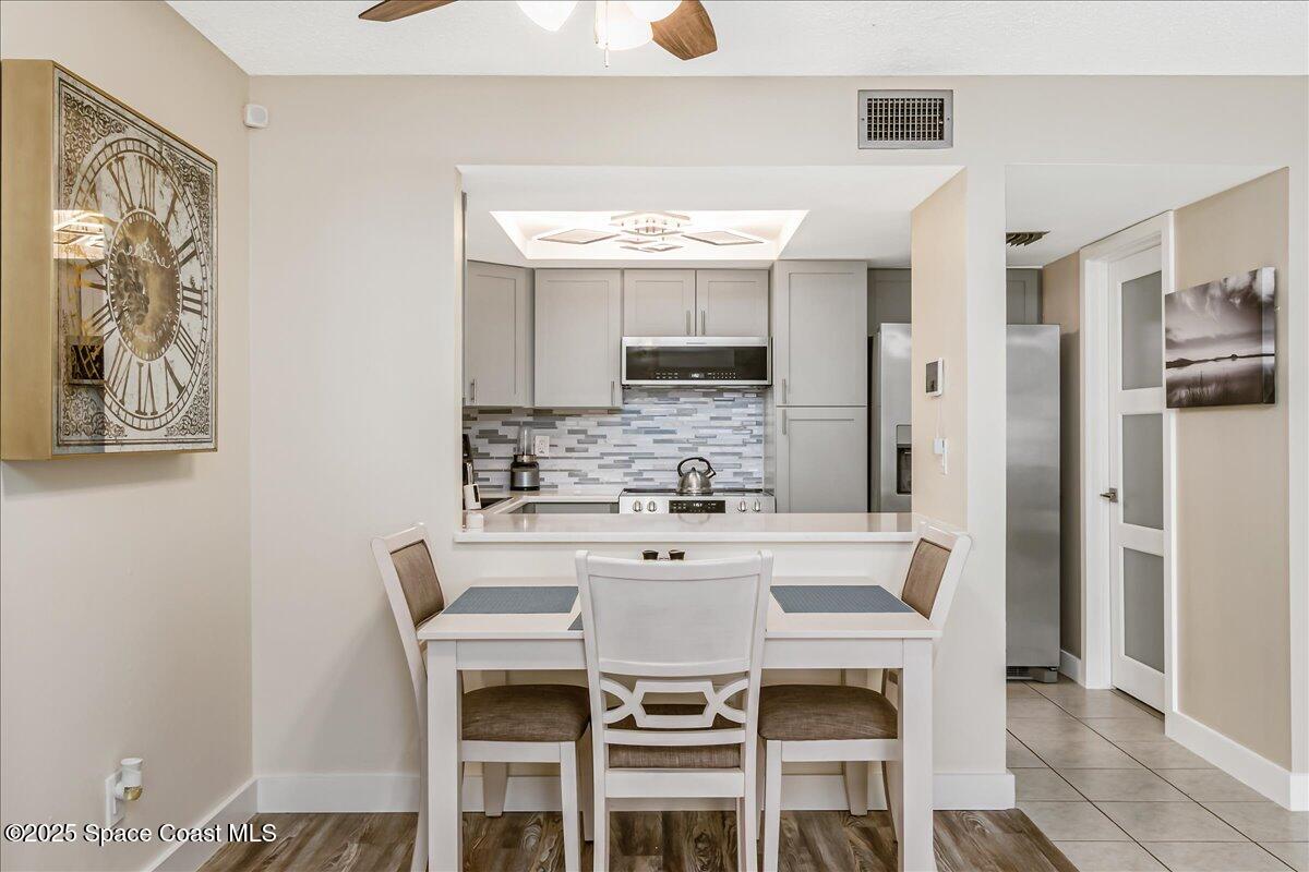586 North Wickham Road, Unit 63 Melbourne, FL 32935 - Photo 20 of 83 a kitchen with stainless steel appliances a dining table and chairs