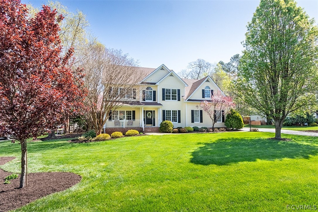 a view of a house with a big yard and large trees