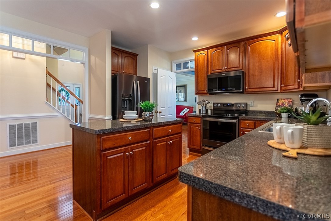 14006 Planters Walk Drive Midlothian, VA 23113 - Photo 16 of 48 a kitchen with kitchen island granite countertop wooden cabinets and a refrigerator