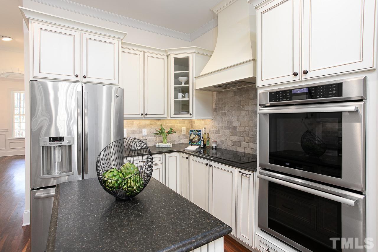 8087 Wake Road Durham, NC 27713 - Photo 12 of 30 a kitchen with stainless steel appliances a stove a microwave and a refrigerator