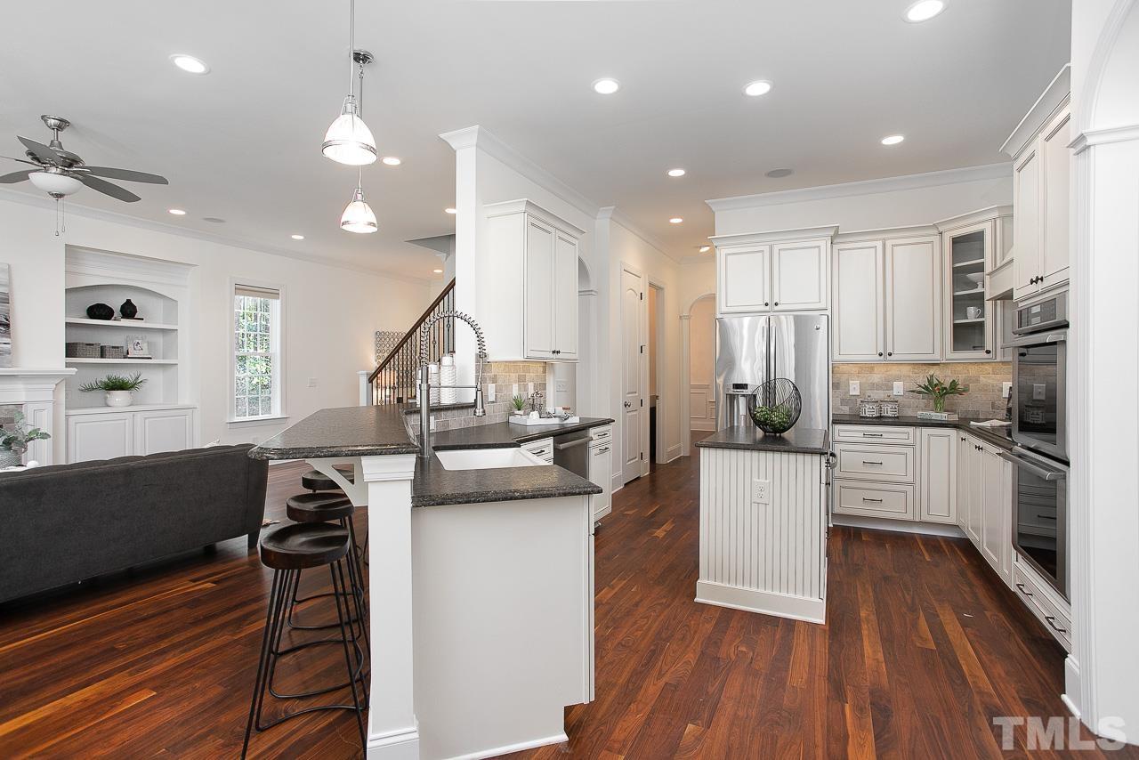 8087 Wake Road Durham, NC 27713 - Photo 14 of 30 a kitchen with kitchen island a counter top space a sink stainless steel appliances and cabinets