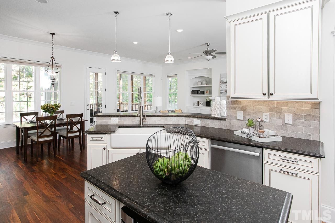 8087 Wake Road Durham, NC 27713 - Photo 15 of 30 a kitchen with stainless steel appliances granite countertop a sink a stove a dining table and chairs