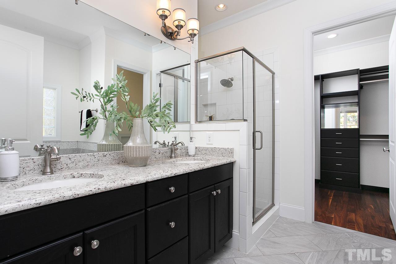 8087 Wake Road Durham, NC 27713 - Photo 18 of 30 a bathroom with a granite countertop sink a large mirror and a shower