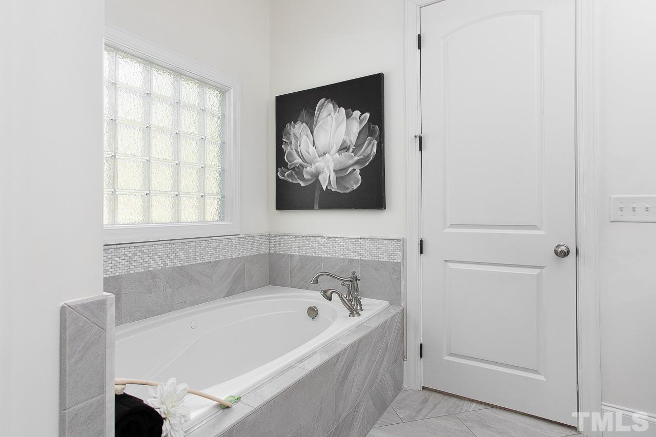 8087 Wake Road Durham, NC 27713 - Photo 19 of 30 a white bath tub sitting next to a window
