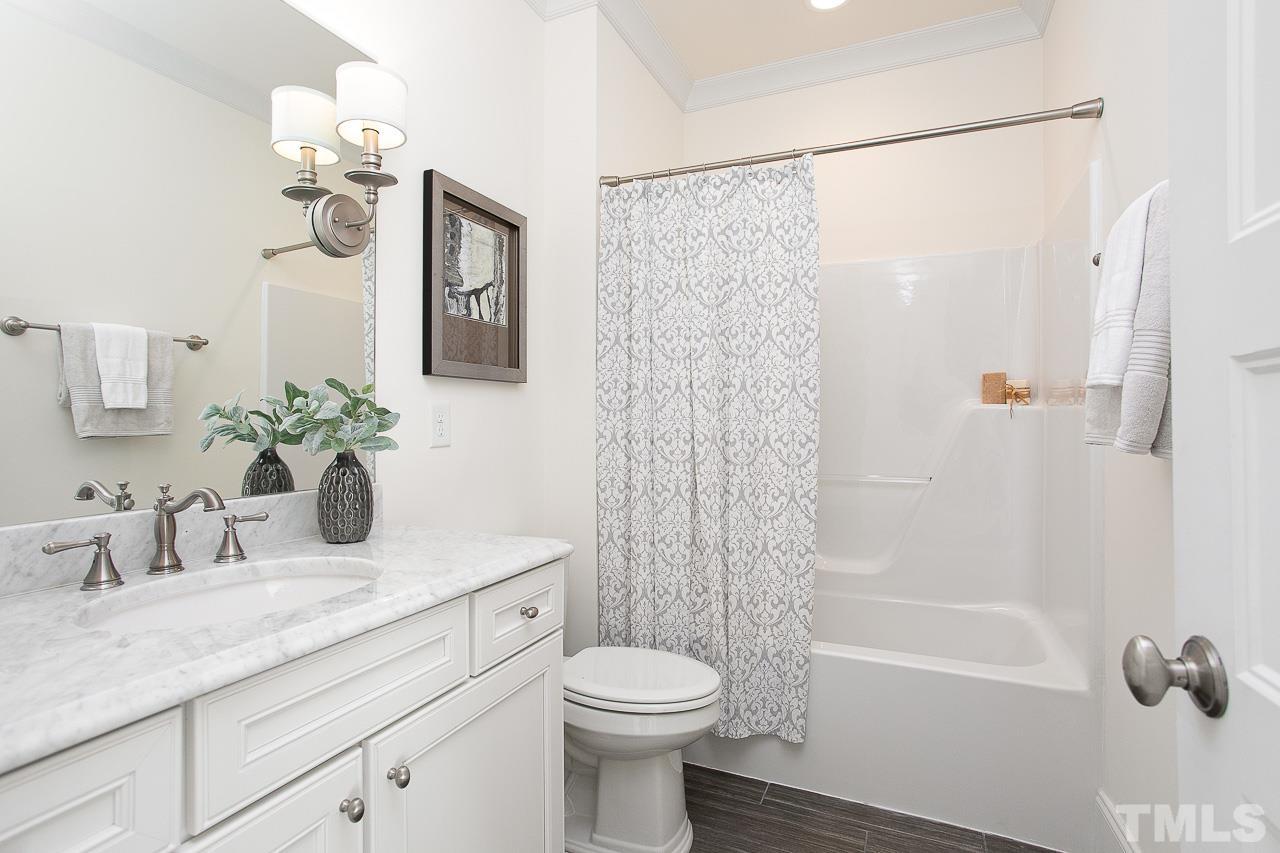 8087 Wake Road Durham, NC 27713 - Photo 23 of 30 a bathroom with a granite countertop sink a toilet and shower
