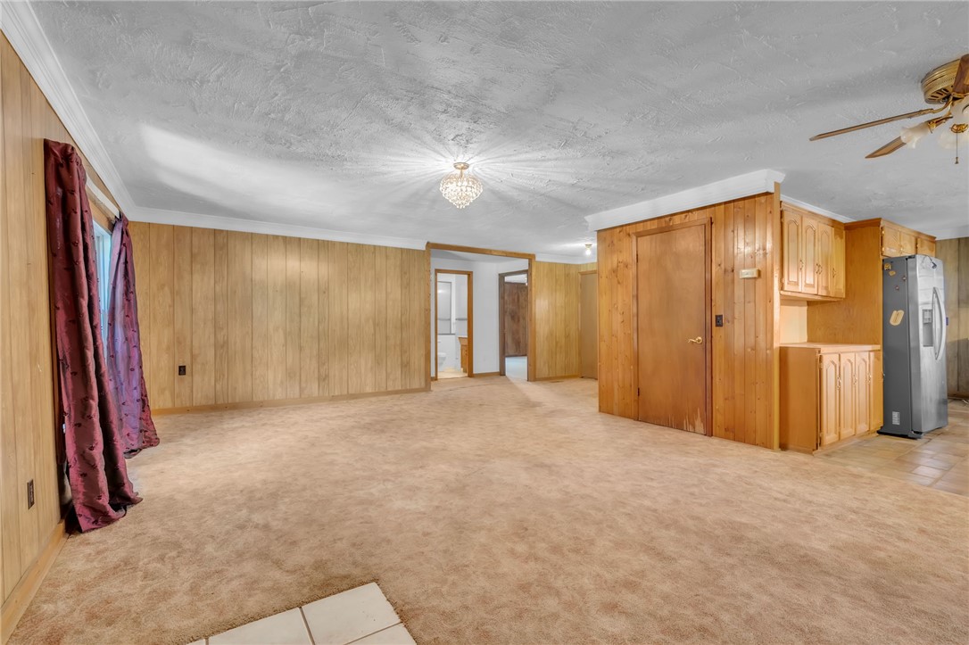 602 Harper Road Pendleton, SC 29670 - Photo 6 of 32 A versatile living area with warm wood paneling and soft carpeting awaits your personal touch.